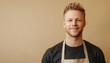 © Руслан Галиуллин - portrait of caucasian smiling young man is 35 years old with apron on beige color background with copy space, cafe owner, startup, small business