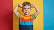 © Mahemud - Little boy in a t-shirt showing muscles on a color background.