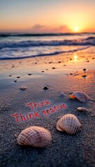 Sticker - 'Think positive' written in the sand on a beach at sunset.