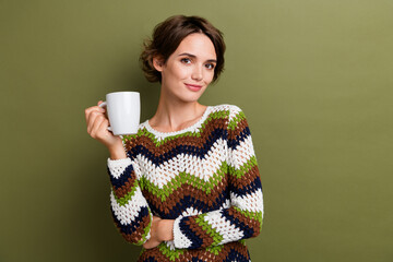 Sticker - Photo portrait of pretty young girl hold white coffee mug wear trendy print knitwear outfit isolated on khaki color background