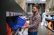 © Serhii - male plumber in a hardware store chooses the sewer pipes, the concept of plumbing work in the house