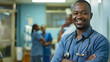 © Mahemud - Smiling African doctor standing in a hospital with his staff