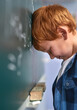 © FotoPush/peopleimages.com - Kid, blackboard and boy in classroom, crying and stress with thinking, depression and anxiety. School, student or upset with autism, learning or pressure with tears, frustrated or emotion with anger