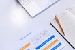 © Wavebreak Media - Analyzing annual report with laptop and notepad, focusing on business growth