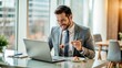 © Olga - Successful businessman enjoying lunch while smiling and working on laptop in a modern office