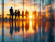 © zphoto83 - A group of professionals stands together, silhouetted against a stunning sunset in a contemporary office. The warm light reflects off polished surfaces, creating a vibrant atmosphere