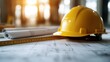 ©  lukaPixMedia - A yellow hard hat resting on construction blueprints under warm sunlight, emphasizing the integration of safety, planning, and design in the construction industry.