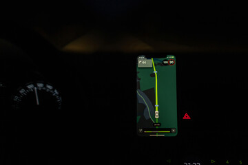 Aufkleber - A smartphone mounted in a car shows a navigation app with directions on a dark, winding road at night
