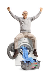 Wall Mural - Happy elderly man sitting on top of a washing machine