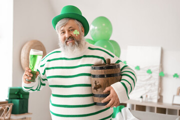 Wall Mural - Mature man in hat with beer at home on St. Patrick's Day