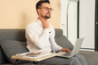 © Pixel-Shot - Young businessman with laptop checking his pulse on sofa in office