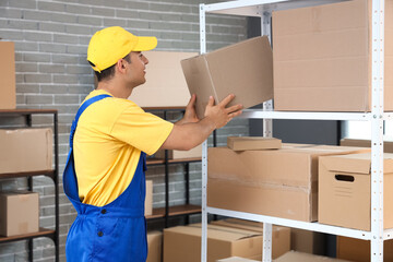 Sticker - Delivery man taking parcel box from shelf in warehouse