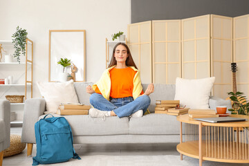 Poster - Happy female student with backpack and books meditating while studying at home