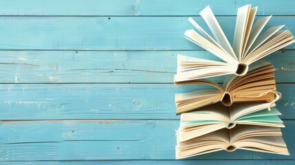 Wall Mural - Open Books on Blue Wooden Background