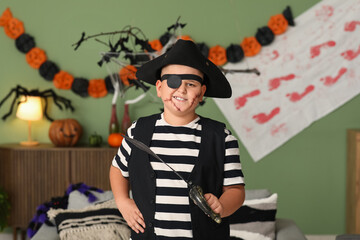 Wall Mural - Cute happy boy dressed as pirate for Halloween party with sword at home