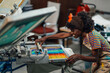 © Zamrznuti tonovi - Happy female diverse worker silkscreen printing on machine at workshop