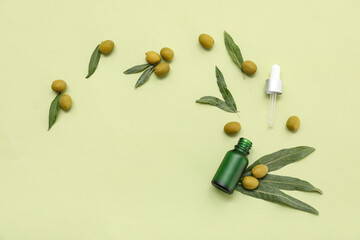 Wall Mural - Composition with bottle of essential oil, green olives and leaves on color background