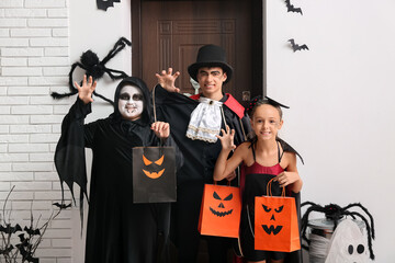 Canvas Print - Kids dressed for Halloween with gift bags at door in hall