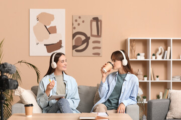 Canvas Print - Young sisters in headphones recording podcast at home