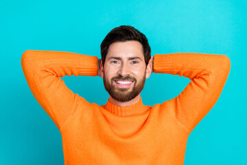 Sticker - Photo of attractive dreamy man wear orange trendy pullover hold arms behind head isolated on cyan color background