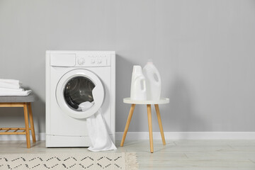 Poster - Washing machine, towels and detergents near grey wall, space for text