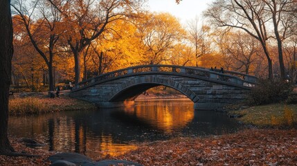 Wall Mural - A serene autumn scene featuring a stone bridge over a reflective pond surrounded by trees.