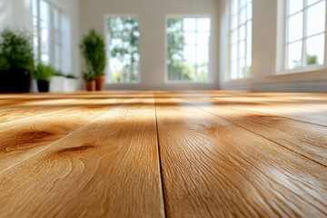 Natural wooden flooring bathed in sunlight, accompanied by green plant decor and large windows, creating a warm and inviting environment with a touch of nature.