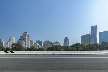 Asphalt road and city skyline with modern buildings scenery. Side view of asphalt road.