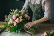 © Instacraft.Studio - A florist is carefully arranging a beautiful bouquet of pink and white roses, creating a stunning floral arrangement for a special occasion.