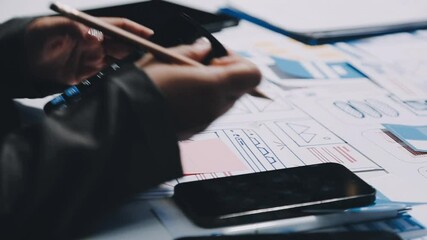ux developers and ui designers, data researchers brainstorm on tabletop mobile app interface wireframe design with client summary color codes the modern office Creative Digital Development Agency.