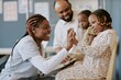 © AnnaStills - African American nurse engaging with young child using educational toy at medical facility while another child and adult observe interaction attentively