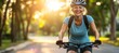 © Ilja - Happy Smiling Senior Woman with Gray Hair Enjoys Riding Her Bike in the Park on a Sunny Summer Day