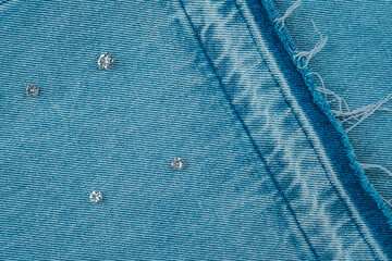 Detailed blue fabric with shiny embellishments and unique patterns showcased on textured surface