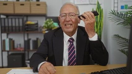 Wall Mural - Elderly man in office talking on smartphone, wearing glasses, smiling, dressed in business suit with tie, surrounded by books, shelves, plants, and desk furniture, creating a professional environment.