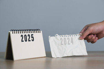 Man's hand pulling a calendar 2024 to 2025. year change from 2024 to 2025. Setup objective target business cost and budget planning of new year concept.