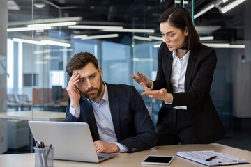 conflicted office scene showing an angry female boss yelling at a frustrated male employee working o