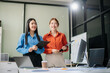 © laddawan - Two Asian businesswoman and man discuss investment project working and planning strategy with tablet laptop computer