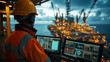 © kongkiat chairat - A worker monitors offshore drilling operations from a control room with advanced technology at sunset overlooking the ocean.