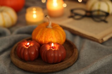 Wall Mural - Burning candles on grey cloth against blurred lights, closeup. Autumn atmosphere