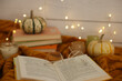 © New Africa - Open book, glasses and autumn decor on warm sweater, closeup