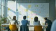 © Pornnapa - A dynamic shot of a team brainstorming new creative business models, with whiteboards filled with ideas