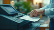 © Aliaksandra - Hand operating a high-tech printer in an office setting, focused on document processing