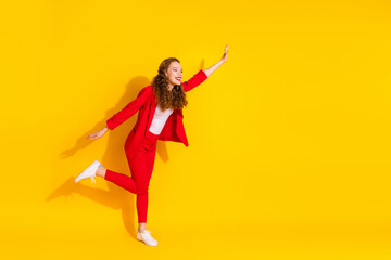 Poster - Full size photo of pretty young woman dance empty space wear red suit isolated on yellow color background