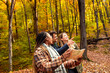© Zoran Zeremski - Three friends having fun and enjoying hiking in forest using map for direction.