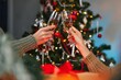© Ruslan - Two women clinking glasses of champagne celebrating Christmas at home.