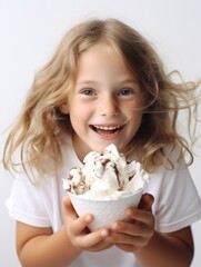 Wall Mural - A young girl is holding a bowl of ice cream and smiling. Concept of happiness and enjoyment, as the girl is excited to eat her dessert