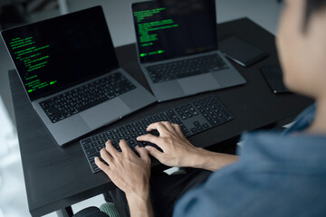 Asian man software engineer Working on Computer at office desk for writing program code IT Software Engineer finding errors tech support devops creating digital