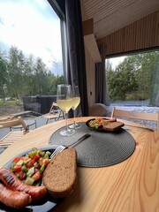 lunch for two in a country house with grilled sausages, salad, bread and drinks in glasses, authentic atmosphere, date, lifestyle