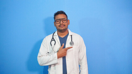 A male doctor pointing to one side with a stethoscope. 