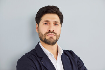 Serious mature bearded male business leader portrait, confident middle aged businessman, handsome CEO, executive in formal suit looking at camera, office wall, posing for corporate photo alone